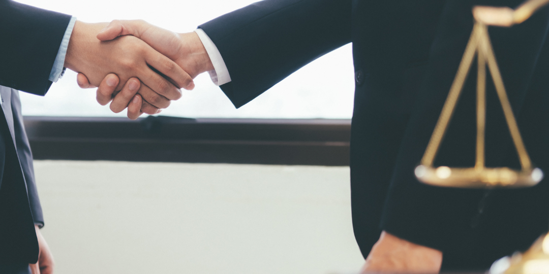 Right solicitor A person meeting the right solicitor for them and shaking hands.