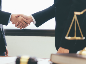 A person meeting the right solicitor for them and shaking hands.