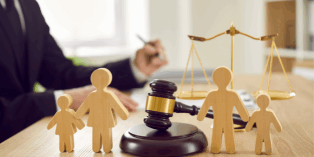 Court Application for a Child – Family Law and Child Arrangements Orders Wooden family figures with a gavel and scales of justice in the background, symbolising child court applications and family law.