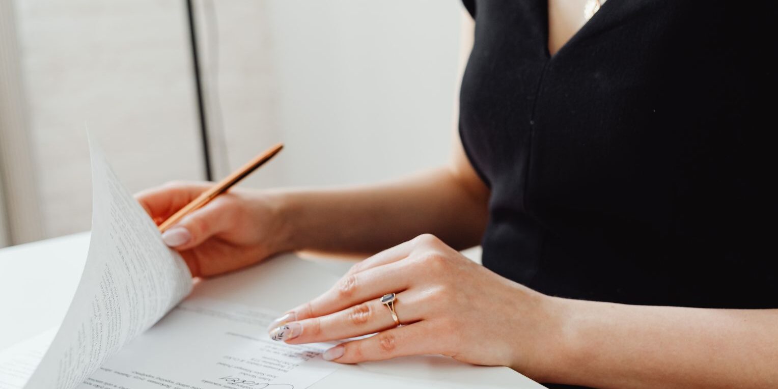 Reviewing a signed Lasting Power of Attorney before OPG registration Woman in black reviewing signed Lasting Power of Attorney document at desk before sending to the Office of the Public Guardian.