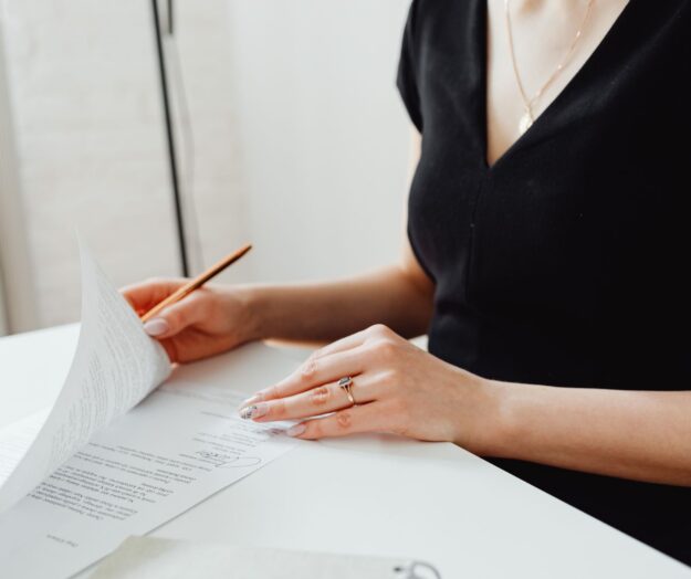 Reviewing a signed Lasting Power of Attorney before OPG registration Woman in black reviewing signed Lasting Power of Attorney document at desk before sending to the Office of the Public Guardian.